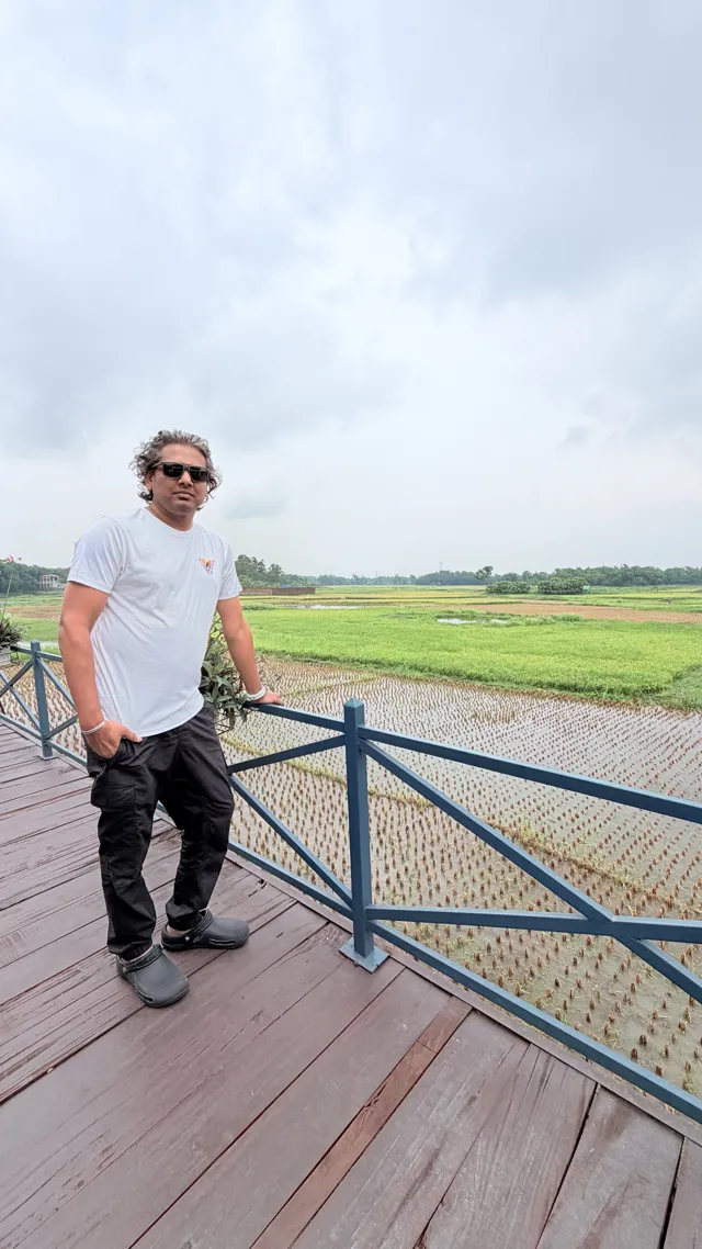 Tawfique Ahmed by a railing overlooking a river and green landscape