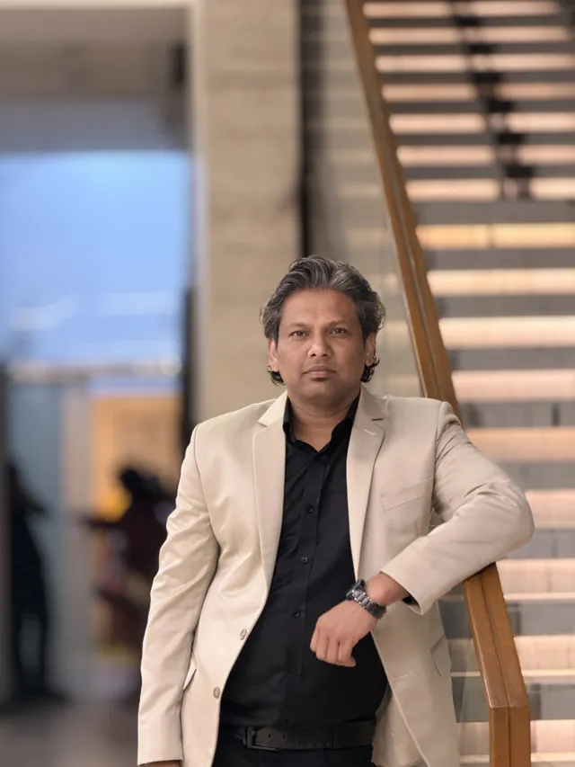 Tawfique Ahmed seated beside a timber staircase